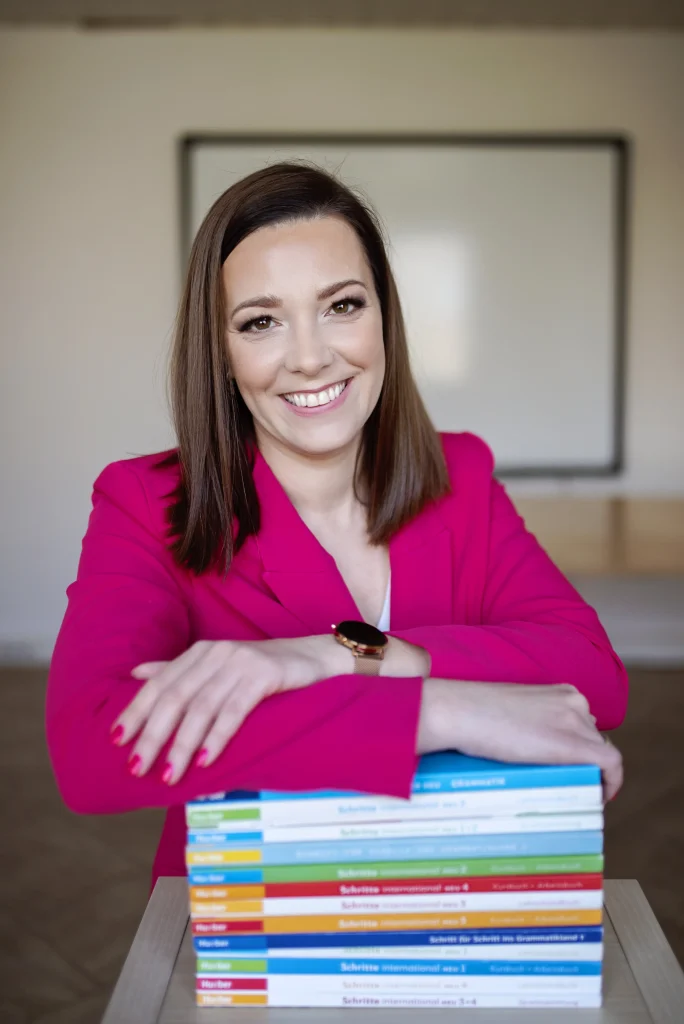 Uśmiechnięta kobieta trzyma ręce na książce